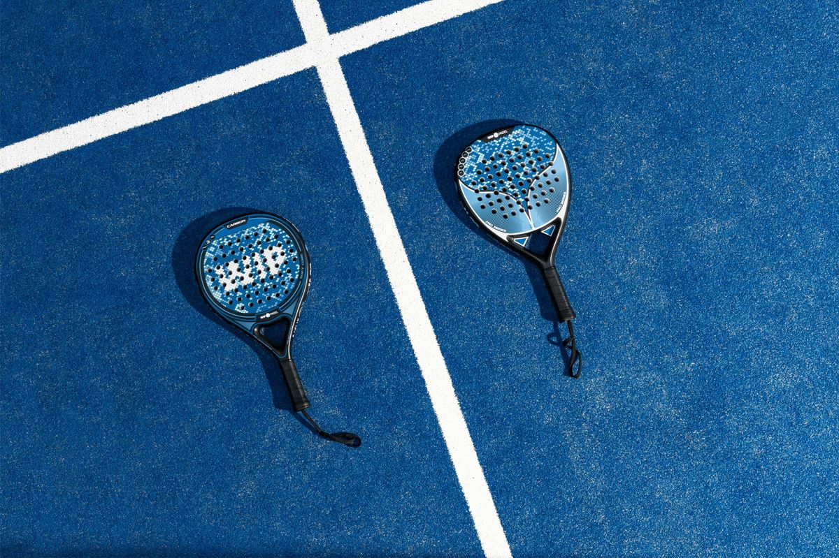 Twee padelrackets tegen het net op een padelbaan